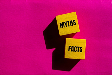 Myths vs Facts blocks on pink background debunking auto accident myths in Florida injury claims.